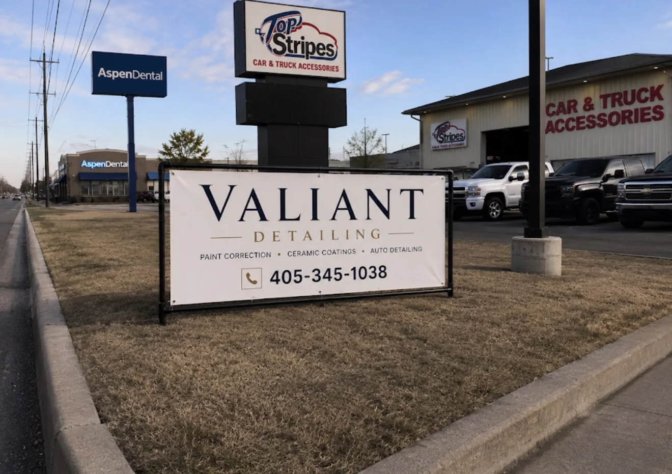 Valiant Detailing roadside sign with 405-345-1038 in front of Tops and Stripes in Enid